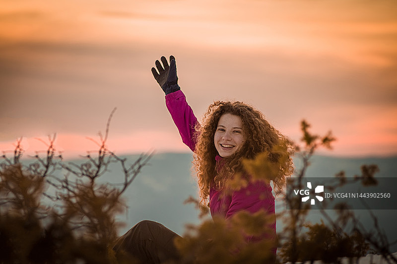 年轻女人在日落背景下玩雪图片素材