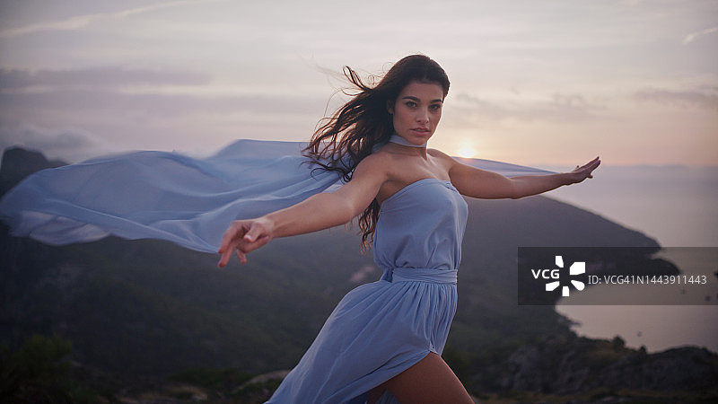 美丽的、自由的、神秘的女子，留着棕色长发，透明的白色面纱随风飘扬图片素材