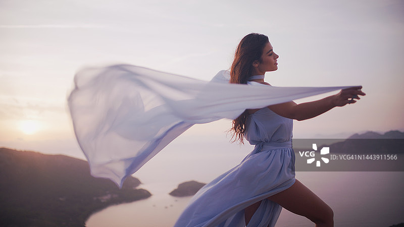 手持透明白纱的棕发神秘美女图片素材