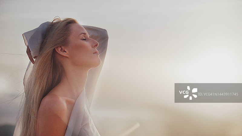 沐浴在阳光下的金色长发白袍女神图片素材