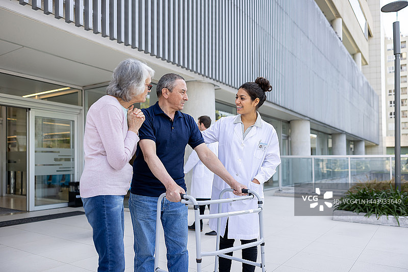 医生在医院看到病人用助行器走路，感到很高兴图片素材
