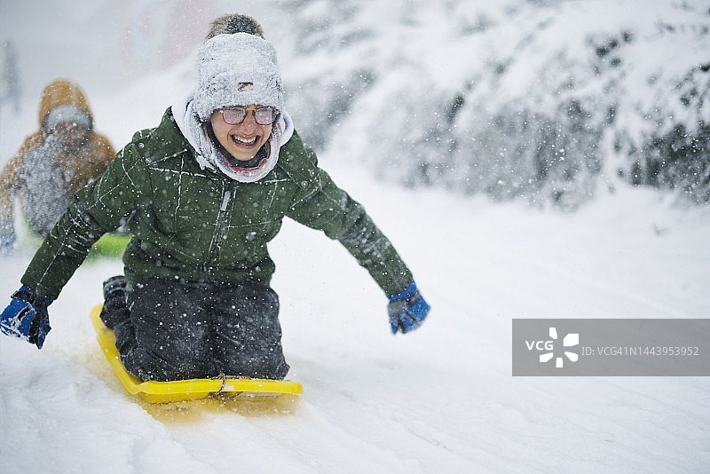母亲和三个孩子在暴风雪中滑雪。图片素材