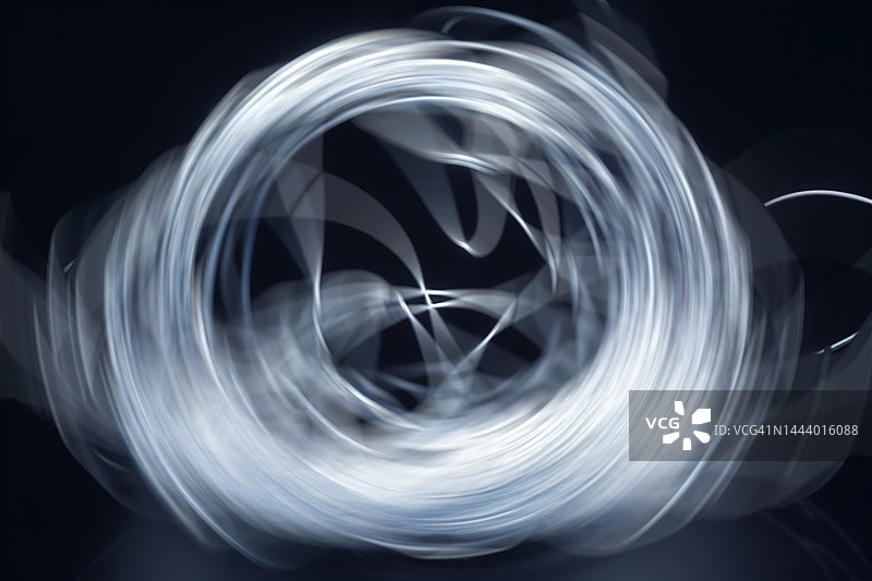 黑色背景上的抽象旋转线条图案图片素材