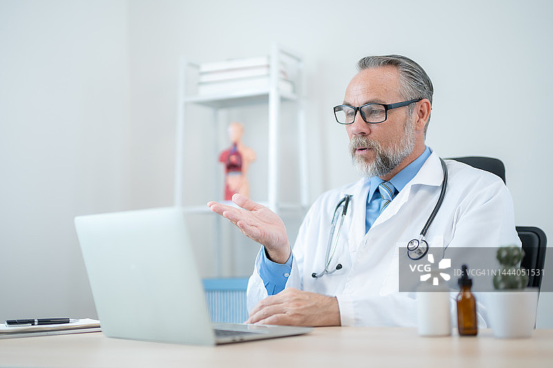 男医生在诊所通过视频通话进行讲解图片素材