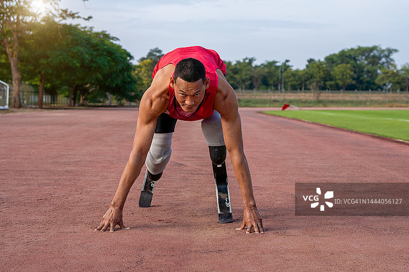体育场赛道上假肢残疾赛跑者起跑图片素材