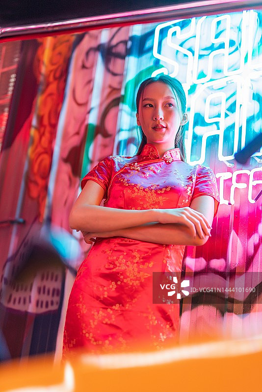 身穿红色中式旗袍、在嘟嘟车旁摆酷的年轻亚裔女模特影棚肖像照图片素材