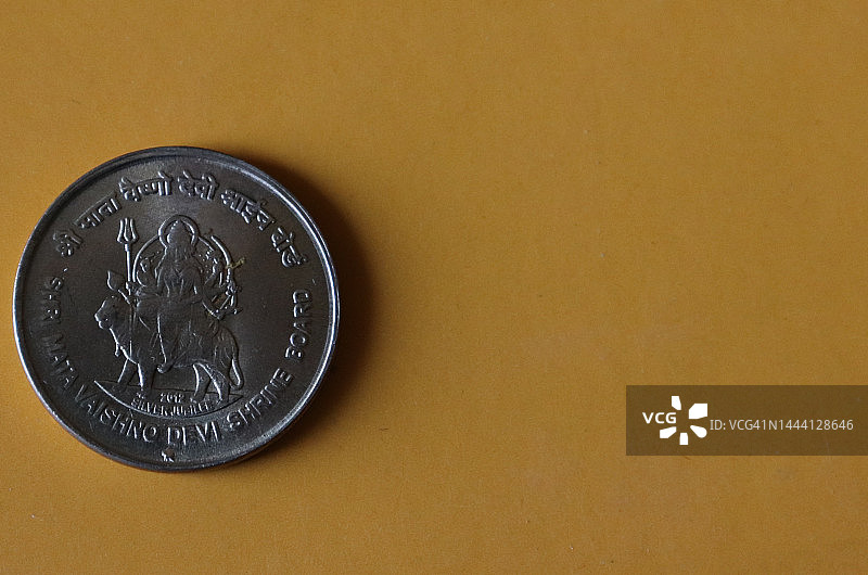 黄色背景下的Shree Mata Vaishno Devi硬币特写图片素材