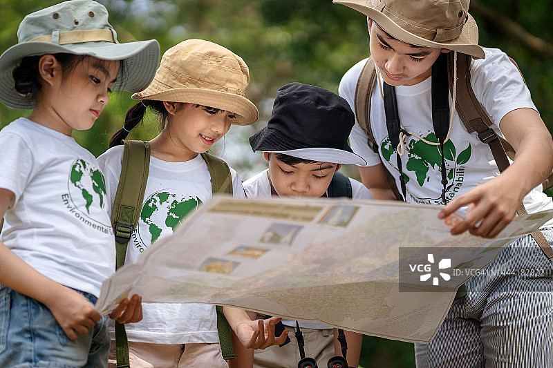 参加实地考察的一群孩子正在看地图练习徒步旅行图片素材
