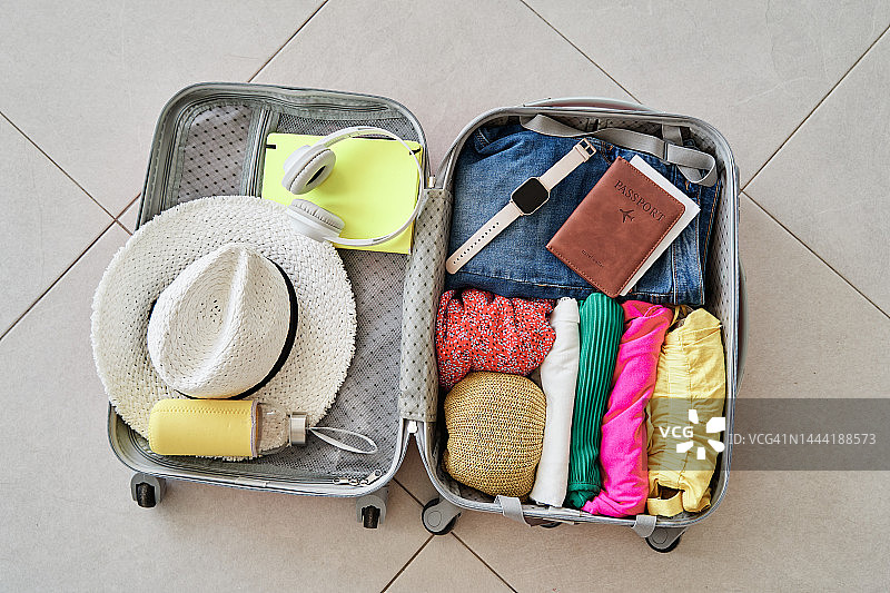 准备好衣服、配饰和护照的打开的旅行箱图片素材