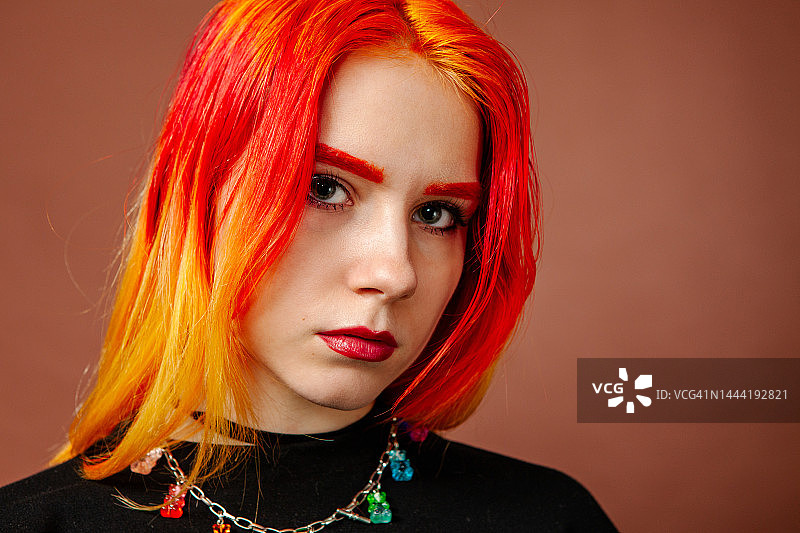 棕色背景前染发的18岁白人女性特写肖像照图片素材