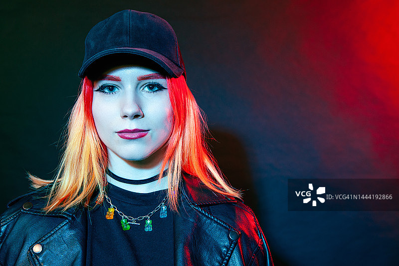 黑色背景下，身穿黑色皮夹克的18岁染发白人女性的特写图片素材