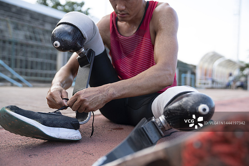系鞋带准备在户外跑步的假肢运动员图片素材