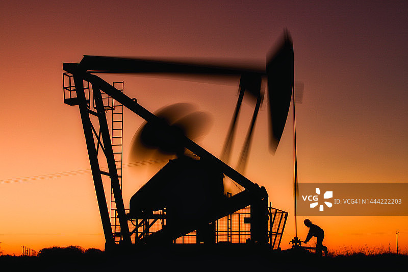 油田工人和抽油井口图片素材