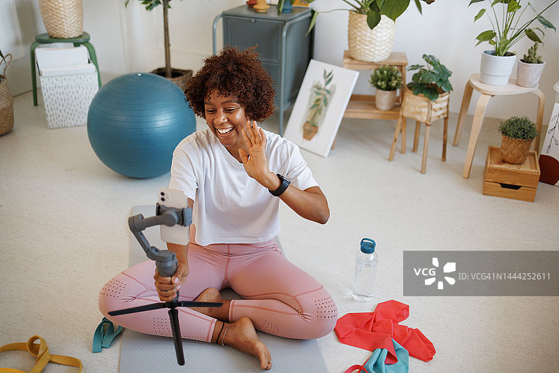 年轻漂亮女人在房间拍摄运动视频博客图片素材