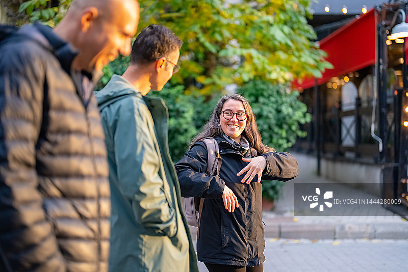 一位女人和两位男人在街上同行图片素材