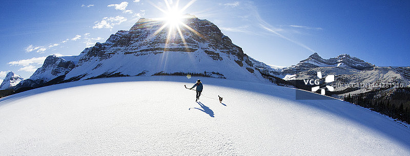 和她的狗在结冰的湖面上滑冰的女人图片素材