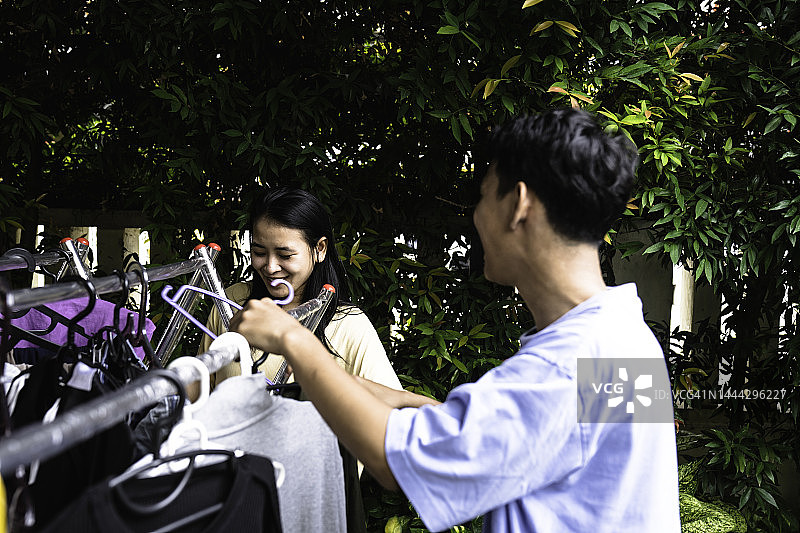 亚洲成年人在晾衣绳上晾衣服图片素材