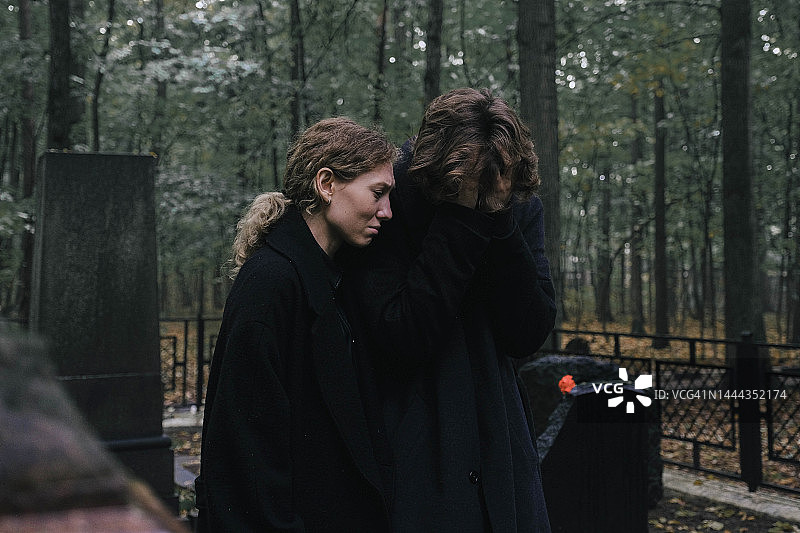 年轻夫妇在墓地悼念逝者图片素材