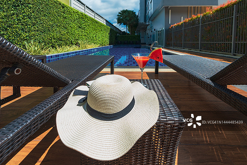 泳池边的草帽与清澈的蓝色水面图片素材