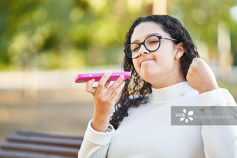 生气和恼火的女人在户外用手机发送语音消息图片素材