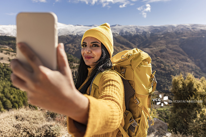 印度女登山者用手机自拍，背包女人对着镜头微笑图片素材