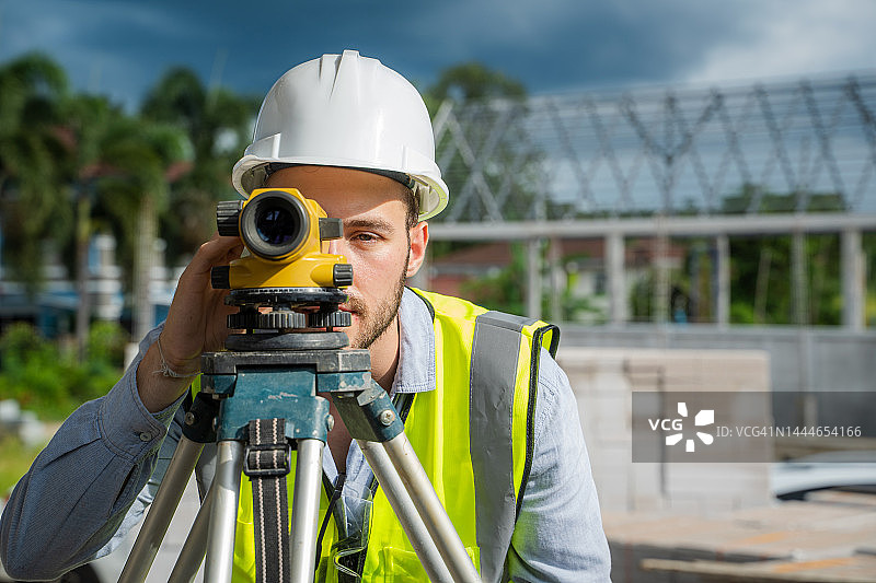 测量员、建筑工人在建筑工地进行测量工作。图片素材
