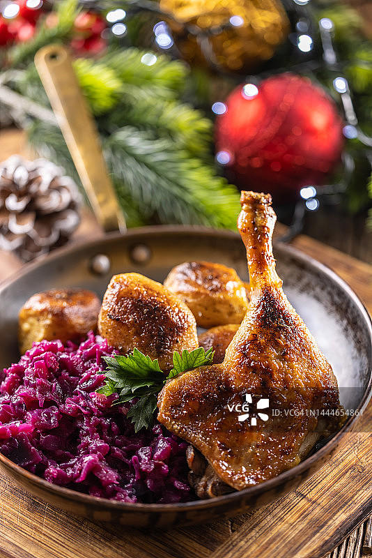圣诞餐桌上的鸭腿或鹅腿，配红甘蓝烤土豆图片素材