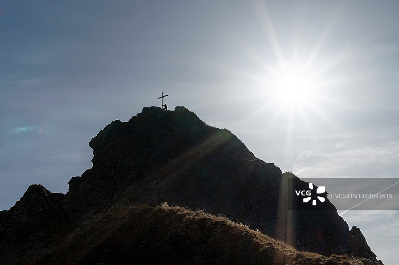 奥地利蒂罗尔：阳光下山顶的徒步者图片素材