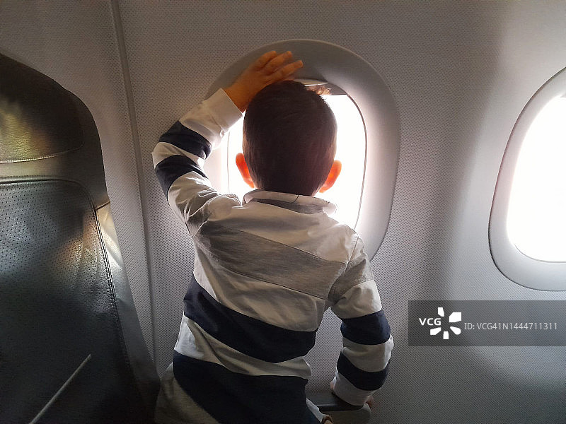 小男孩看着飞机窗外图片素材