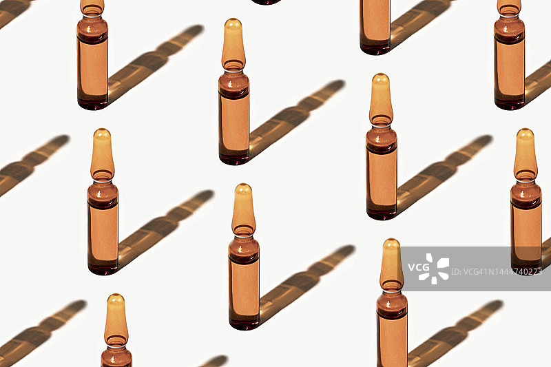 玻璃安瓿图案：含透明质酸和维生素C的药品或化妆品，白色背景带阴影图片素材