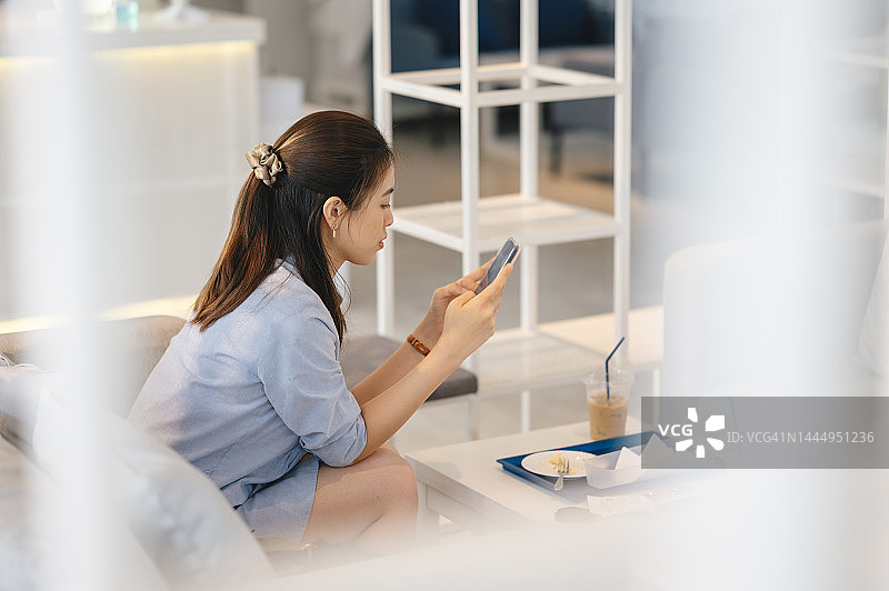 快乐的年轻女子使用现代平台学习硕士学位技术，以便在咖啡馆与同事联系并在任何地方工作图片素材