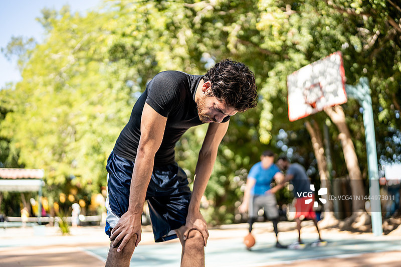 在篮球场上疲惫的年轻人图片素材