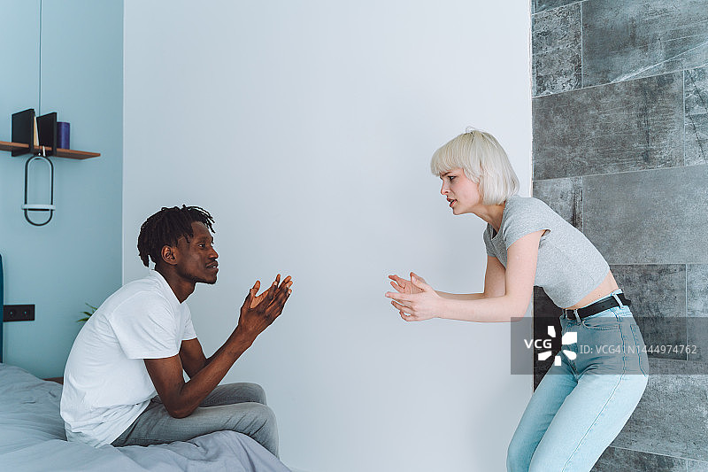 离婚与分手：年轻的多种族夫妇在卧室里争吵和尖叫图片素材