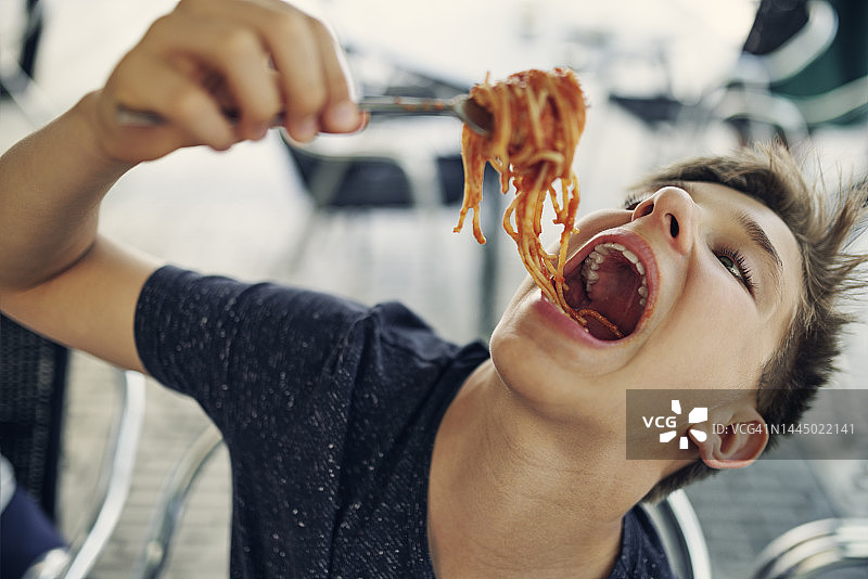 青少年男孩非常喜欢吃意大利面图片素材