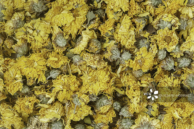 木桌背景上的干菊花茶特写，用于自制化妆品图片素材