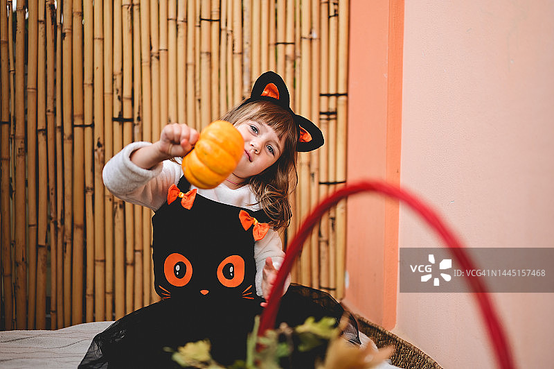 万圣节，在露台上抱着南瓜的小孩图片素材
