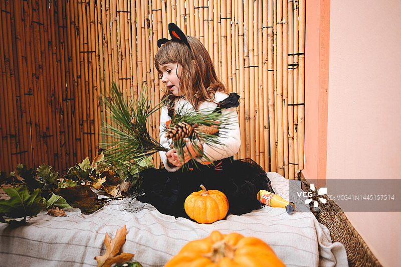 露台上玩耍的女孩与树叶标本图片素材