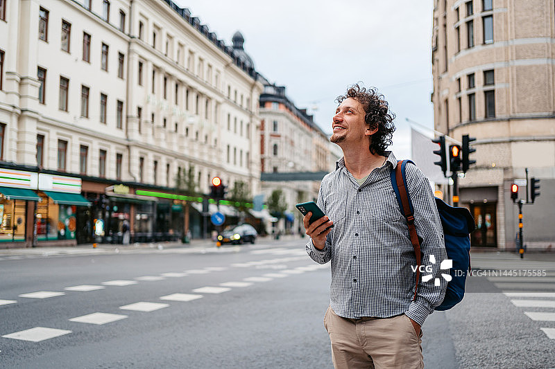 在斯德哥尔摩街头使用手机的年轻男人图片素材