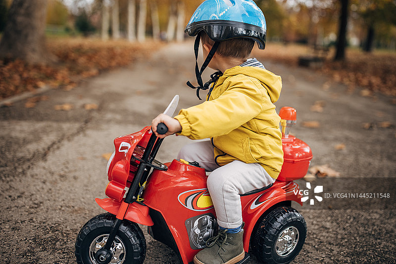 小男孩骑玩具摩托车图片素材