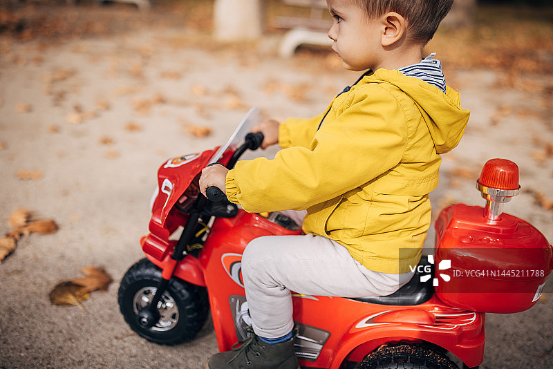 小男孩骑玩具摩托车图片素材