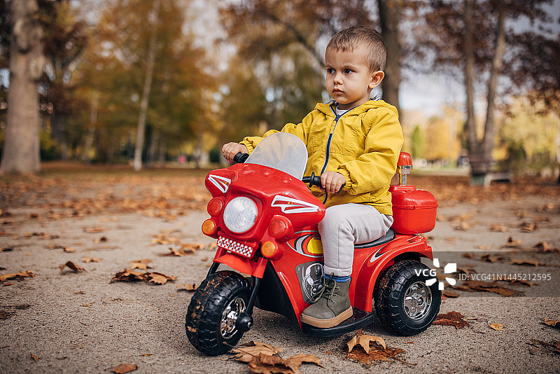 小男孩骑玩具摩托车图片素材
