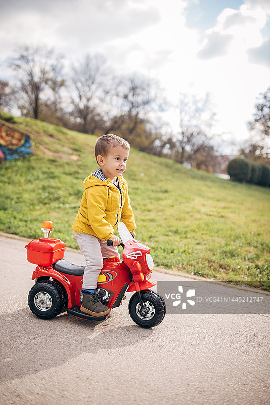 在公园里骑玩具摩托车的男孩图片素材