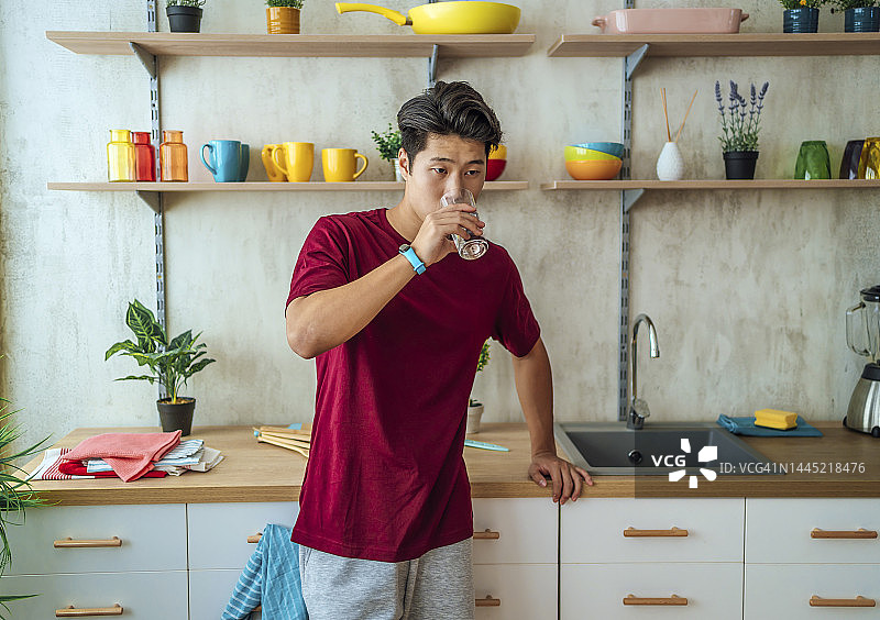 年轻男人在家喝水图片素材