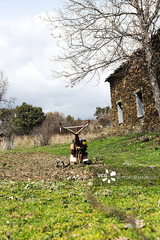 偏远乡村的耕地机和农舍：乡村旅游概念图片素材