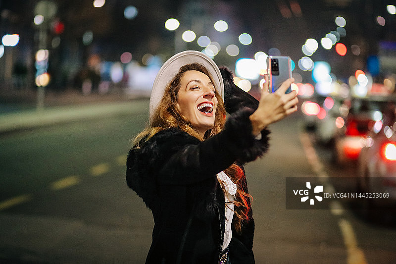 美丽的女人在街上自拍夜景图片素材
