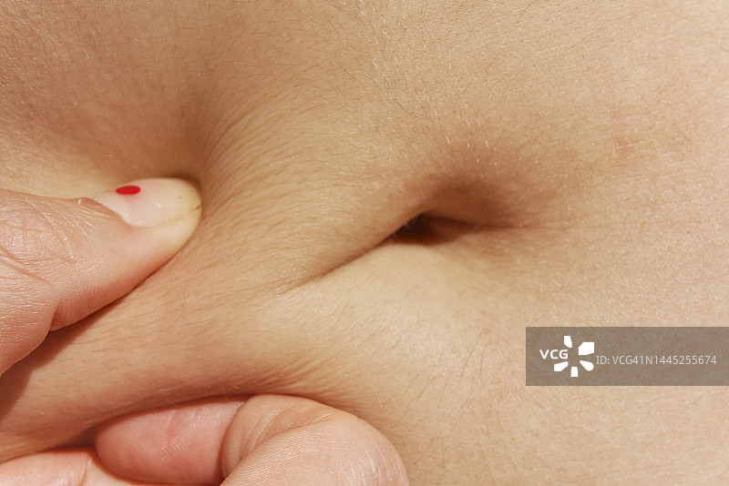 女人手检查腹部脂肪的特写图片素材