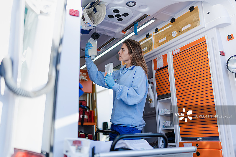 医生检查救护车内的医疗设备：医疗急救与准备概念图片素材