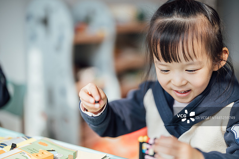 亚裔儿童在家高兴地玩积木 - 摄影素材图片素材