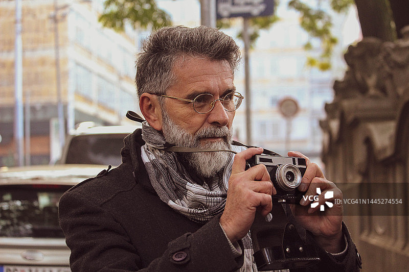 在街上拍照的复古老年男人图片素材