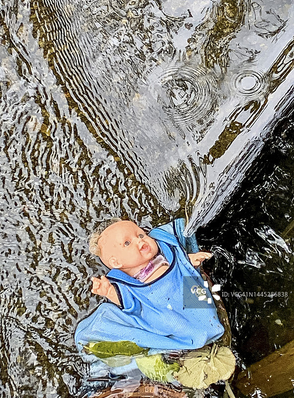 掉入水中的蓝色玩偶图片素材